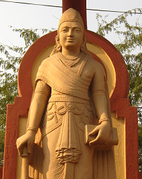 Chandragupta - Statue of a standing young man in red stone.